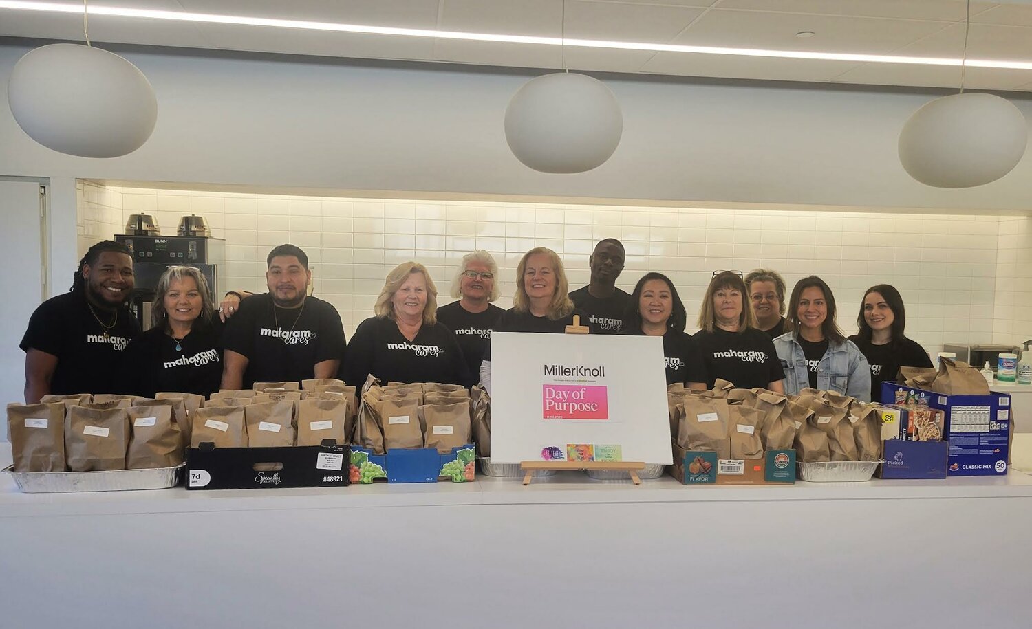 Employees at Maharam in Yaphank with bag lunches they assembled for the soup kitchen at St. Joseph the Worker Church in East Patchogue.